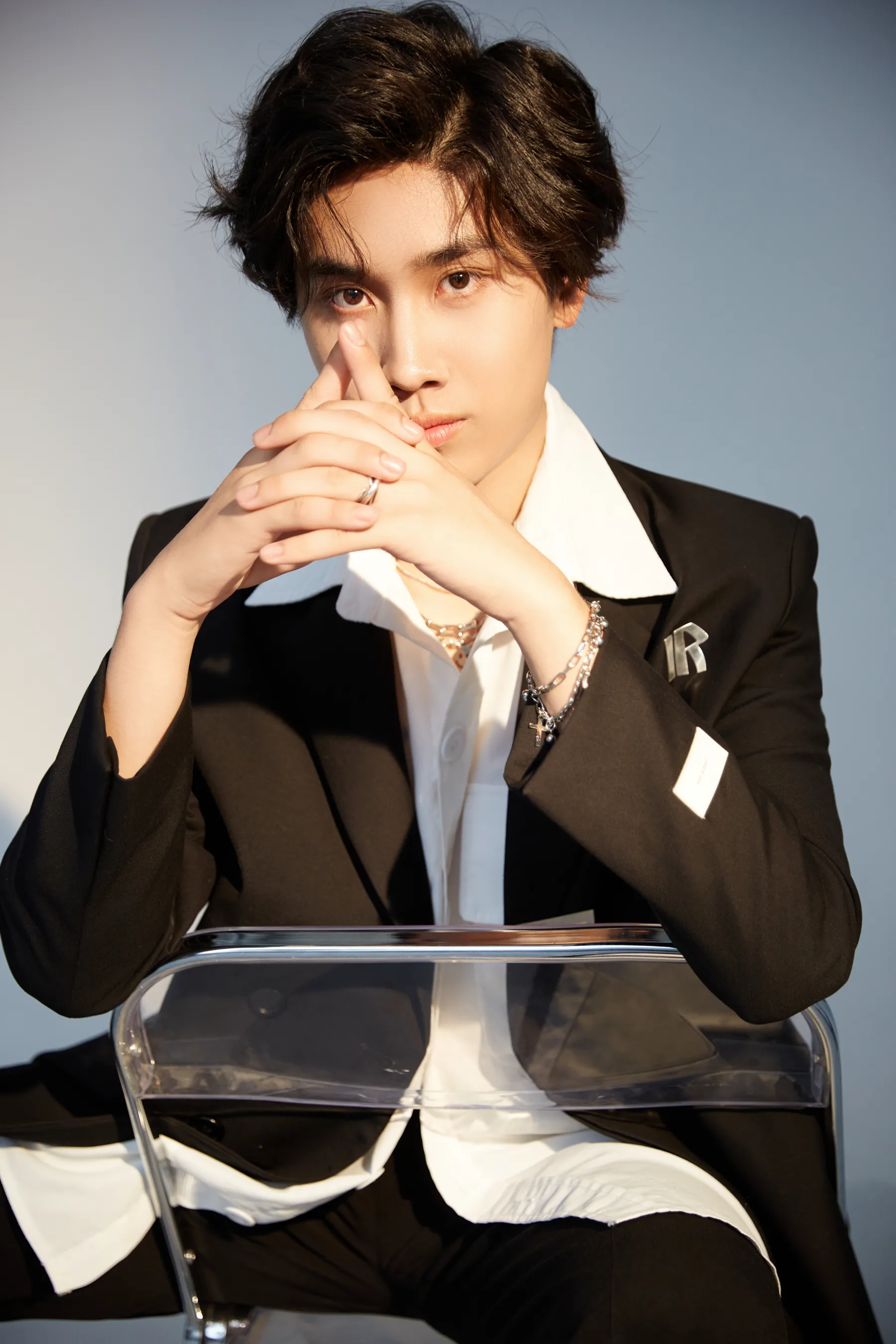 KSONG in a black suit seated in warm light
